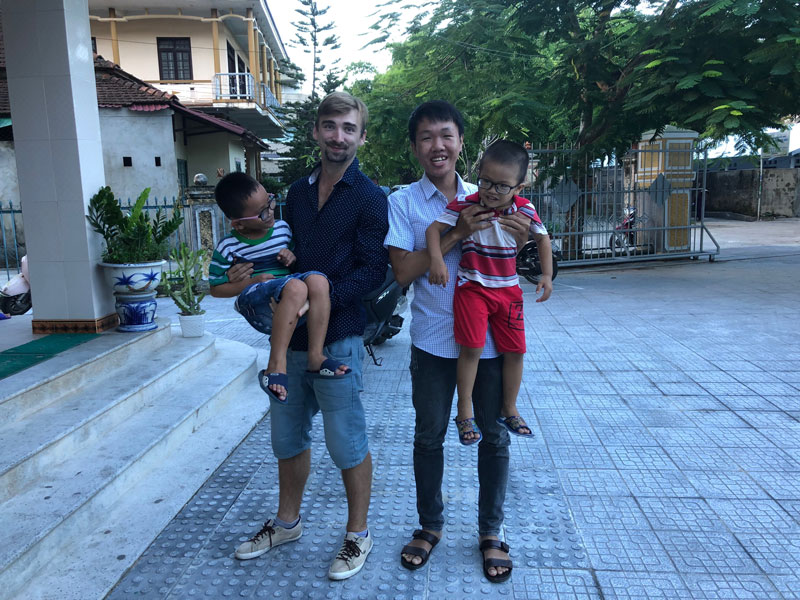 Lubomir Novohradsky and Bảo Phước are holding Blind kids