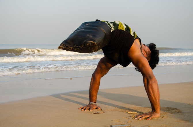 Mumbai beach and disable person who does not have two legs and he is able to manage handstand
