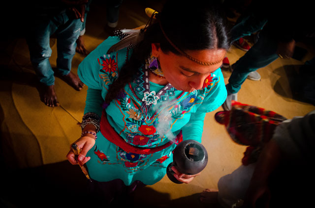 Indiánka fouká do dýmky a hraje si s kouřem (indiánská tradice).