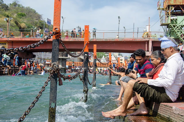 Indové si umývají nohy v řece Ganga. 